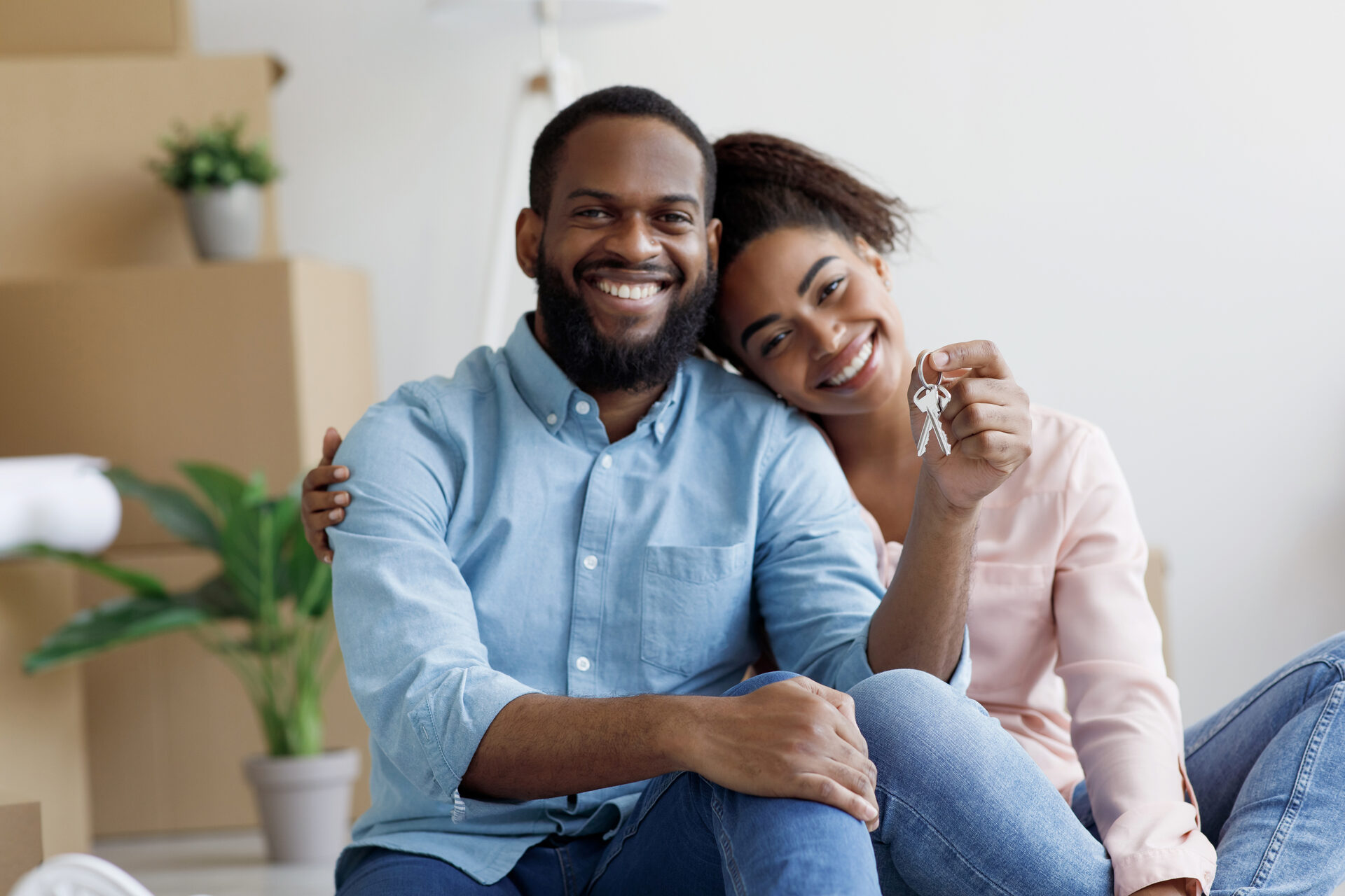 A Jamaican family carrying boxes into their bright new home on moving day